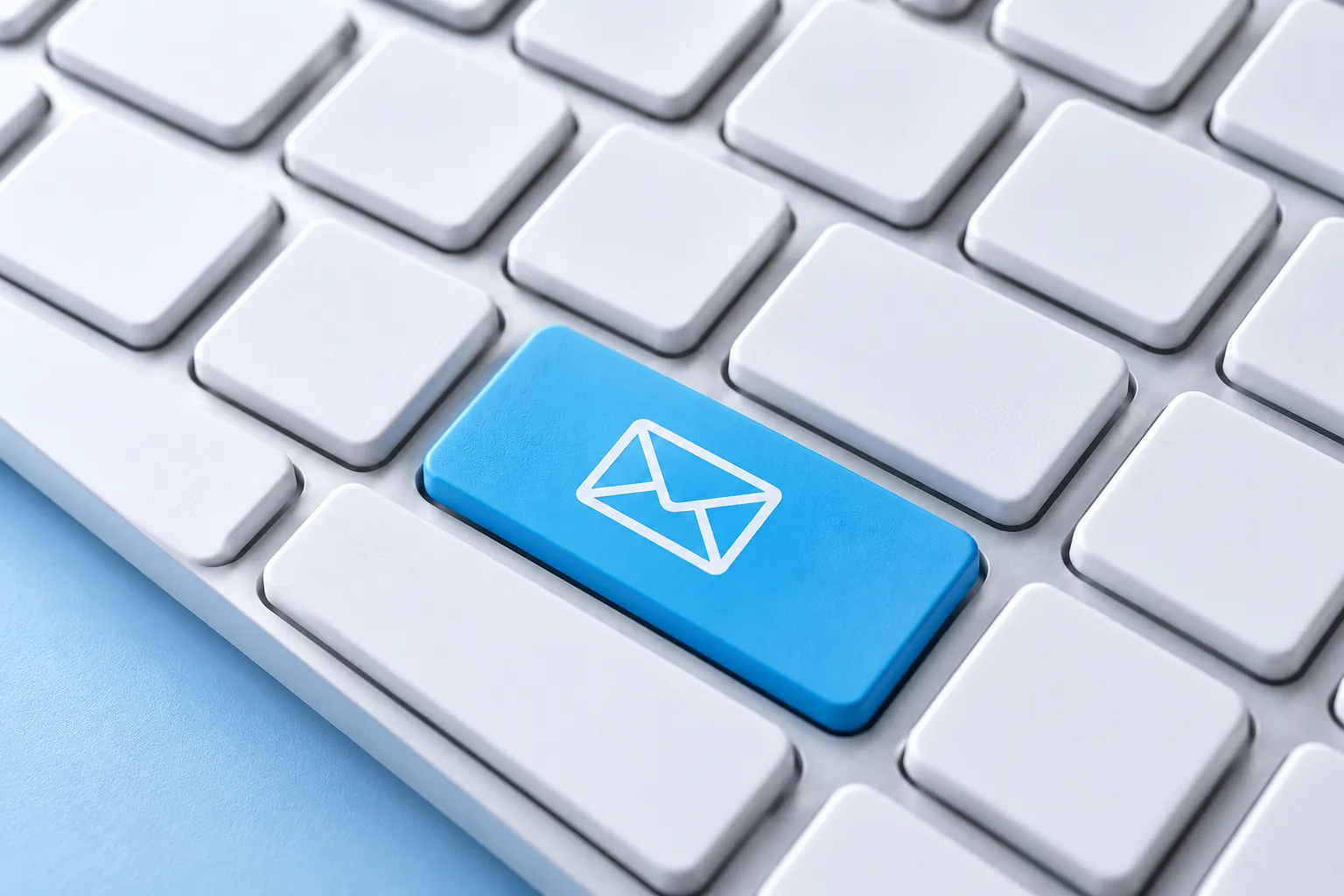 A computer keyboard with a blue key showing an envelope icon